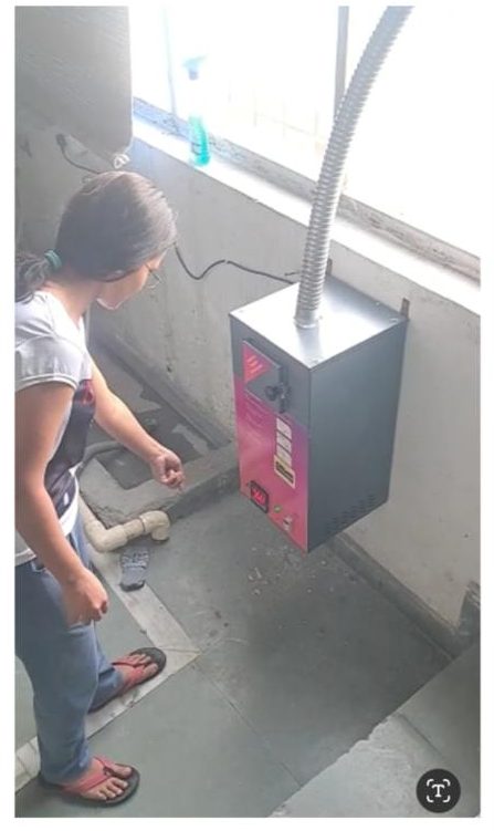 Wall-mounted Techlance sanitary napkin incinerator with flue pipe in the girls' hostel washroom at IIM Sirmaur