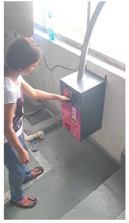 A student using the Techlance incinerator in the IIM Sirmaur girls' hostel